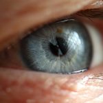 Na imagem aparece o close de um olho de cor azul, de uma pessoa idosa.